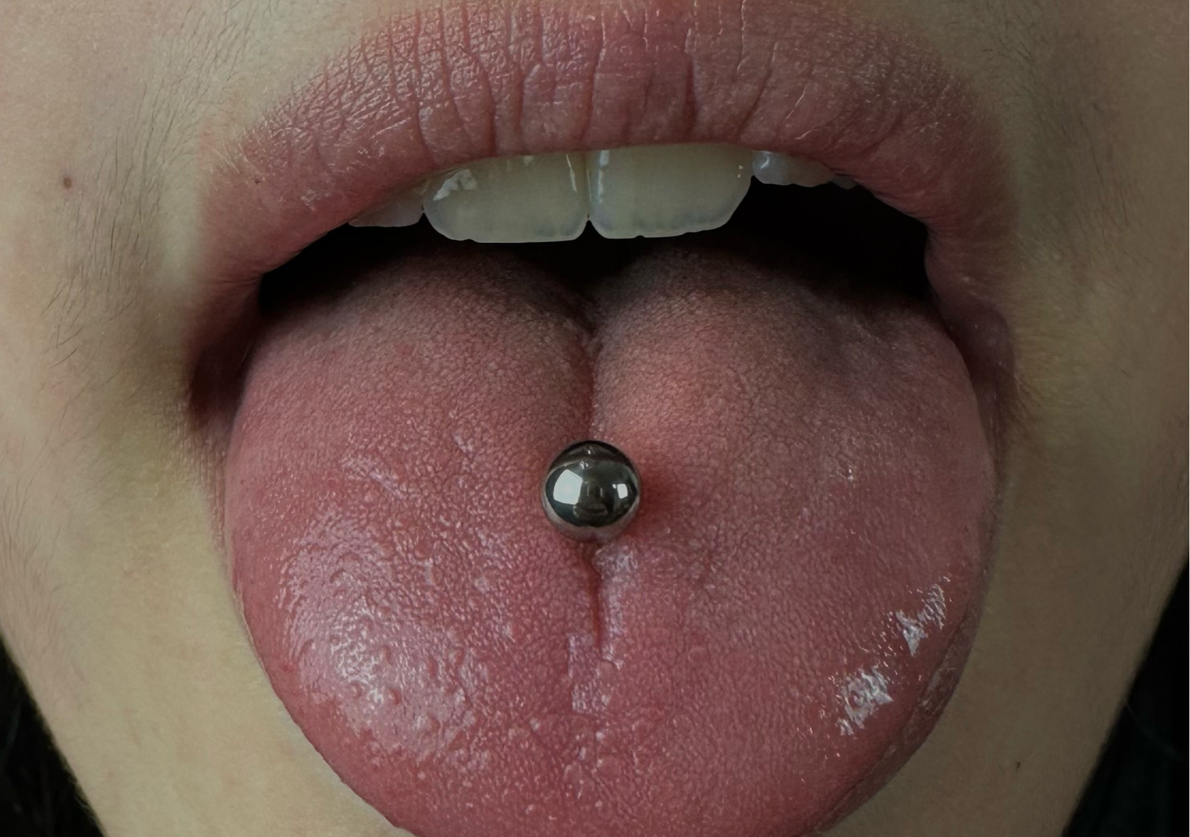 Piercing vertical à la langue (vertical tongue piercing)