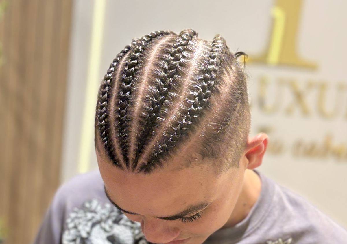 Cuatro trenzas frontales de hombre en el cabello natural